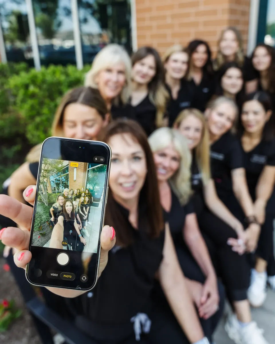 Pura Vida staff group taking a smiling selfie together outdoors