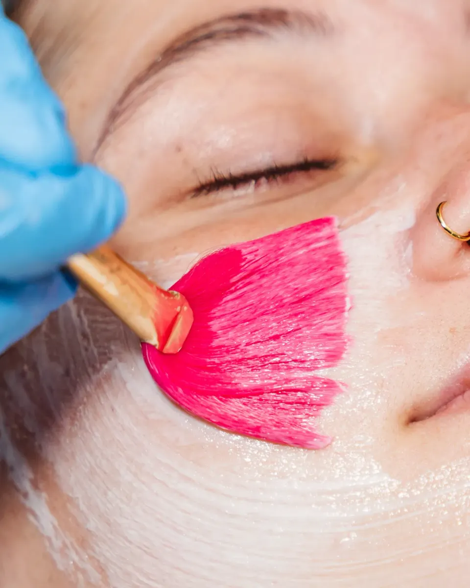 Esthetician performing a professional skin treatment on a relaxed patient