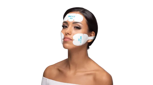 Woman wearing Emface applicators on the forehead and cheeks for non-invasive facial lifting and toning at Pura Vida Med Spa in Fulton Maryland