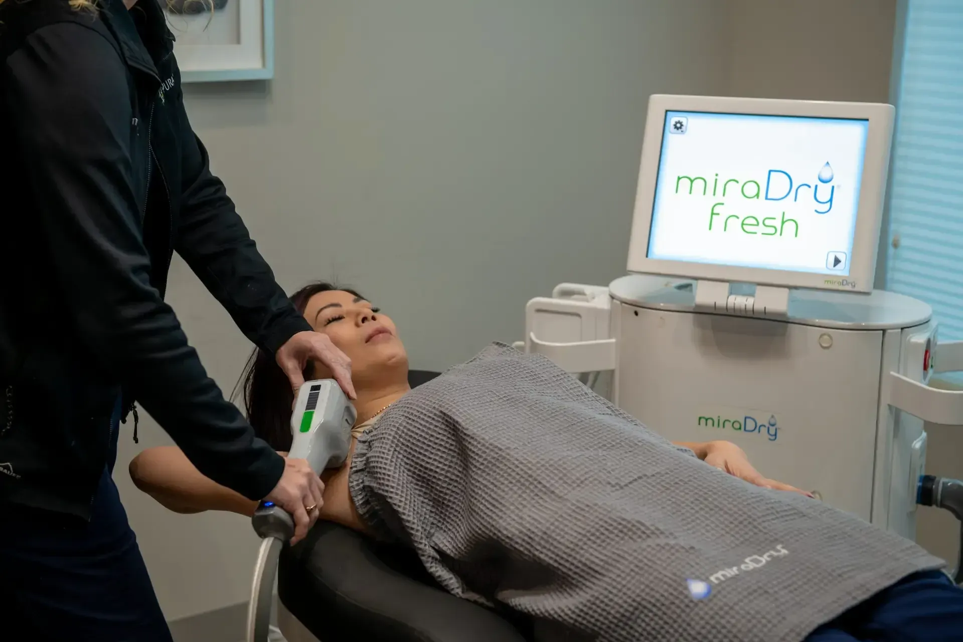 Confident woman raising her arms after MiraDry treatment at Pura Vida Med Spa in Fulton, MD
