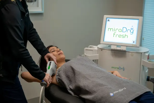 Confident woman raising her arms after MiraDry treatment at Pura Vida Med Spa in Fulton, MD