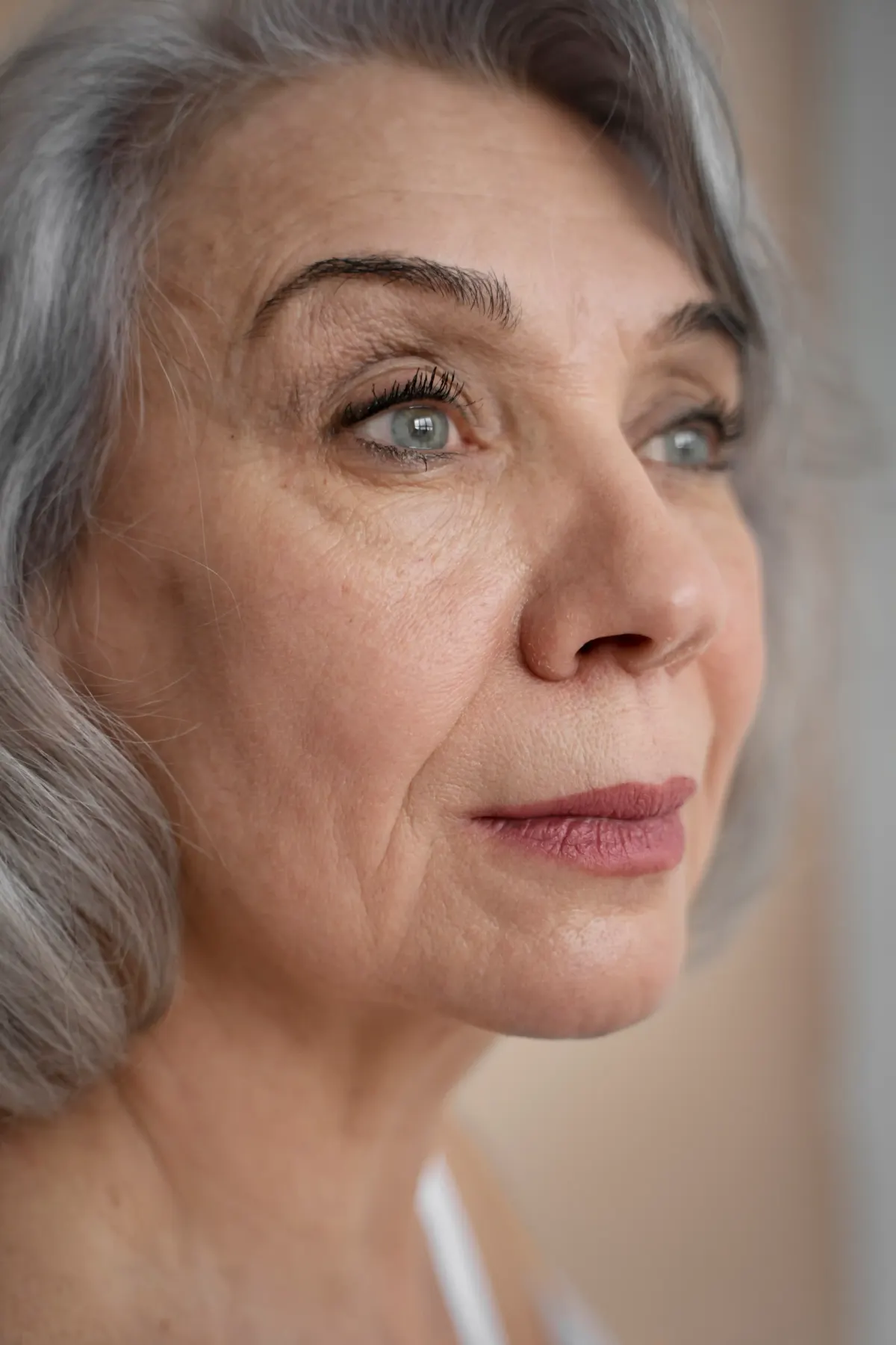 Close-up profile of elegant older woman with gray hair and mature skin