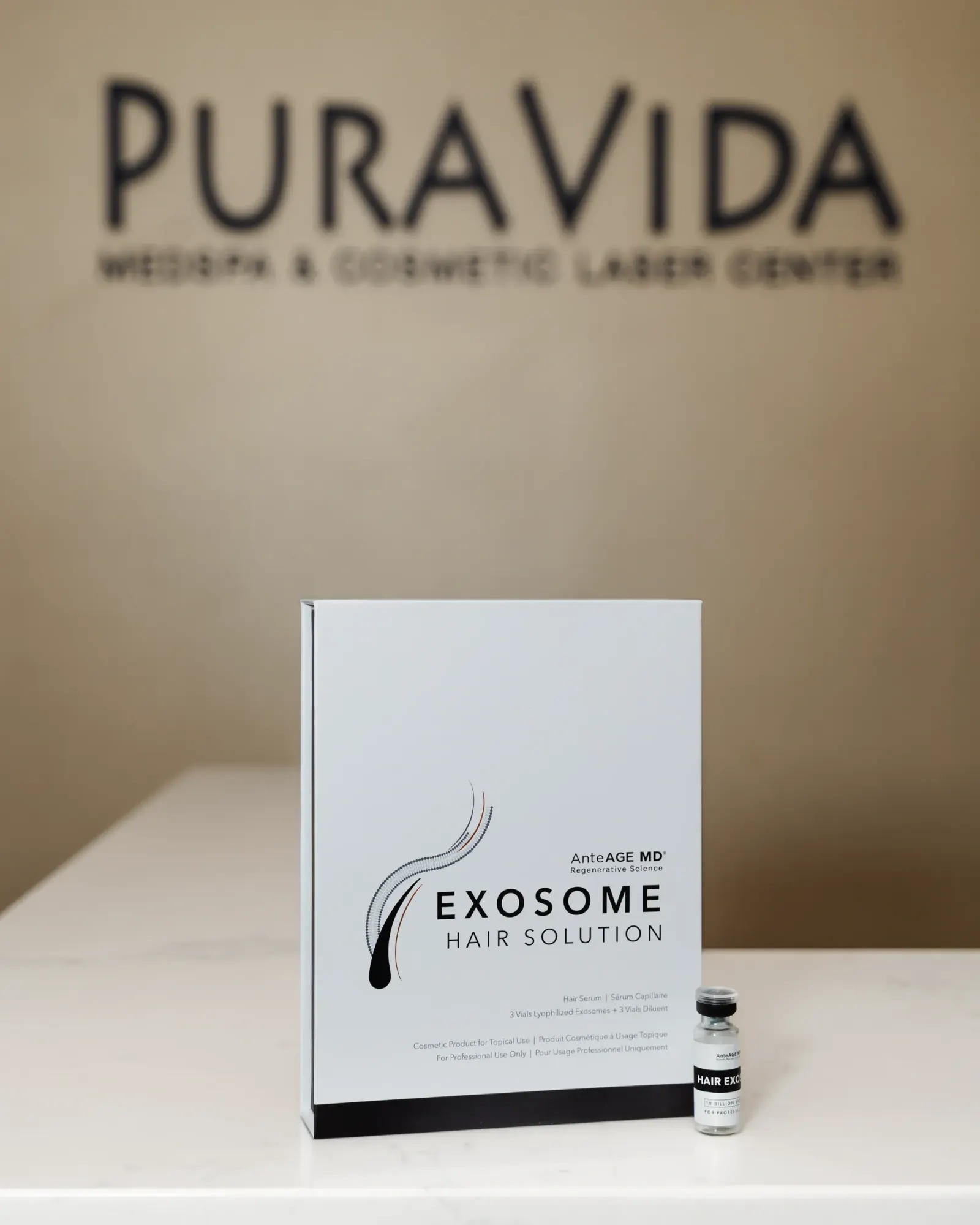 Exosome hair solution box and vial displayed beneath the Pura Vida logo