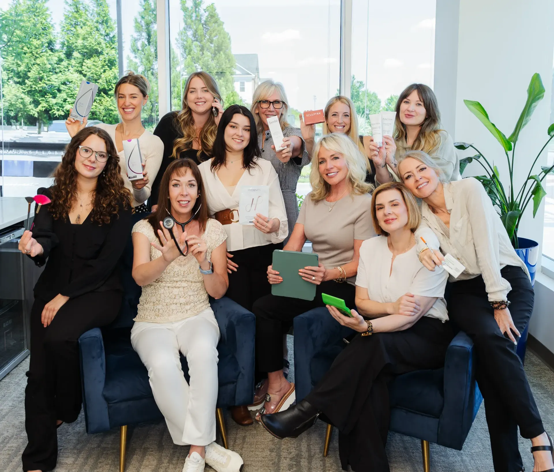 Pura Vida Med Spa team of women smiling together on a couch in the clinic lobby