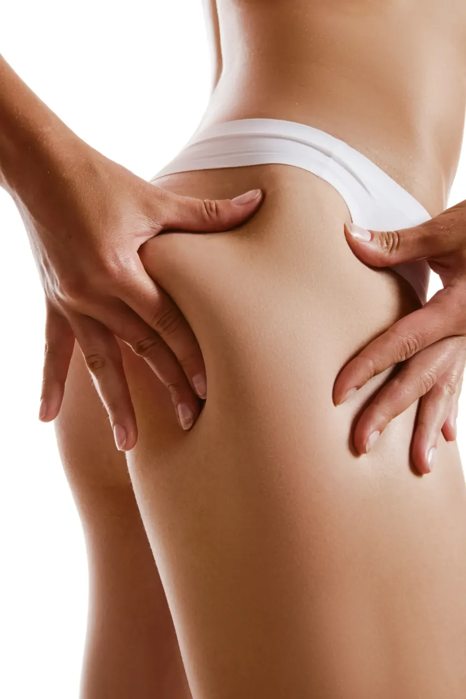 Hands pinching the skin of a woman's thigh to show cellulite